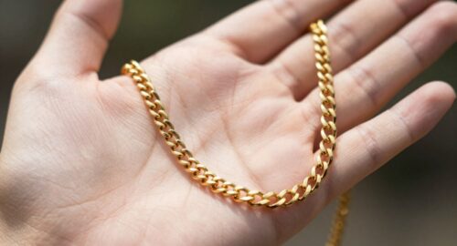 Hand holding a shiny gold chain necklace
